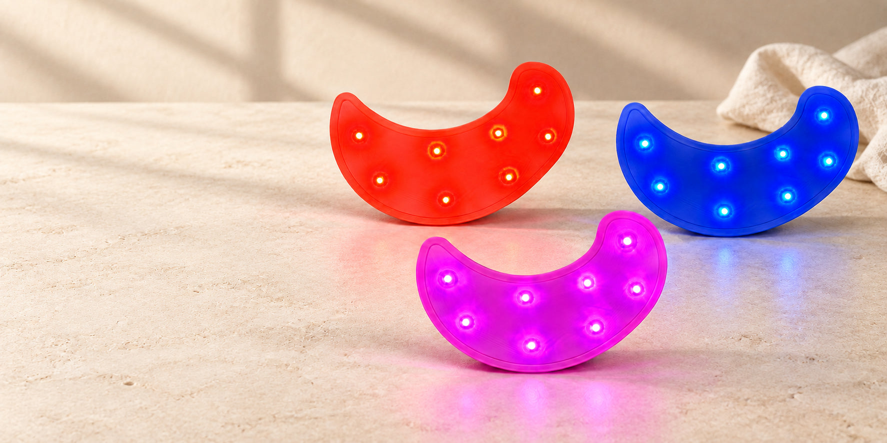 The three GGC LED light modes on a warm stone surface with natural linen behind them