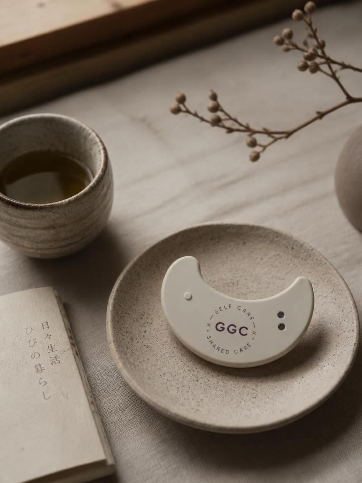 GGC patch on a ceramic plate beside tea and a book with its original Japanese lettering