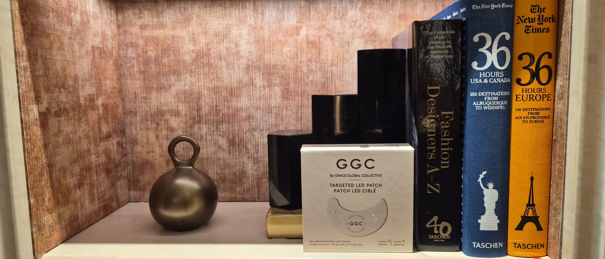 GGC packaging on a bookshelf beside blue and mustard travel books
