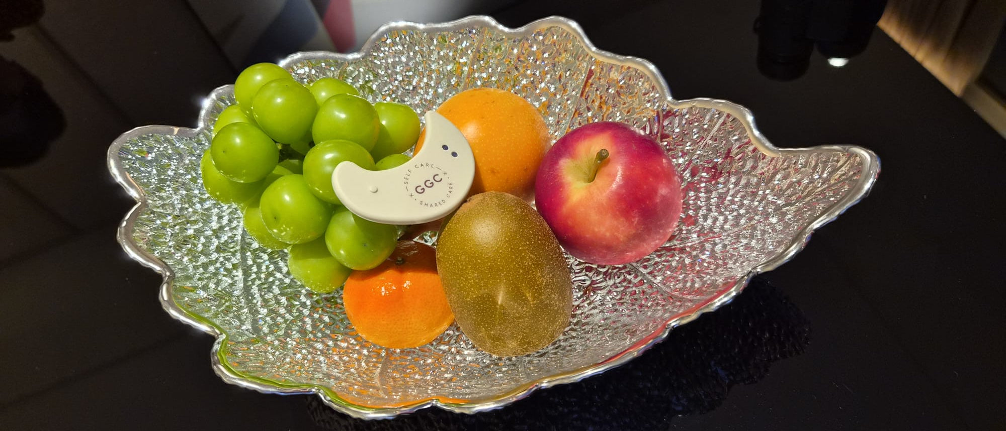 GGC LED patch among fresh fruit on a silver leaf-shaped platter